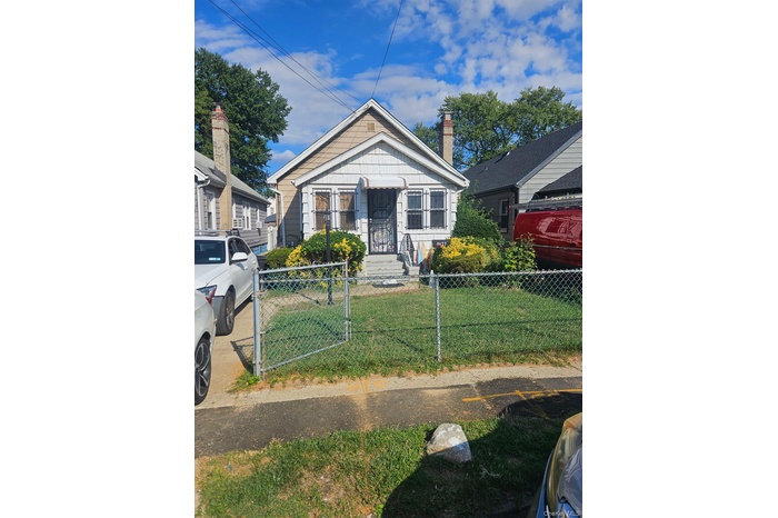 Bungalow featuring a chimney and a fenced front yard