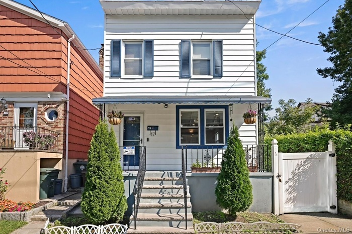 View of front of property with stairs and a gate