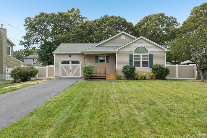 Ranch-style house with a porch, asphalt driveway, and a garage