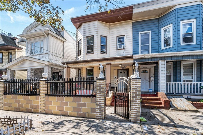 View of front of home with covered porch, a gate, and cooling unit