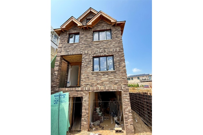 Back of house featuring brick siding and a patio area