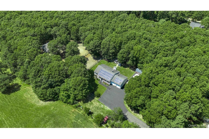 Aerial overview of property's location with a heavily wooded area