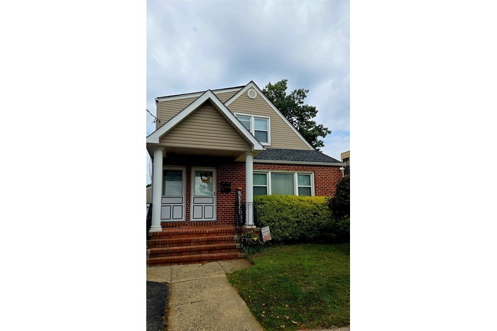 Bungalow-style home featuring brick siding, a front yard, and entry steps