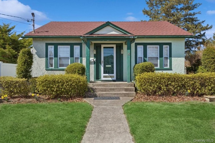 Bungalow-style home with a front lawn and stucco siding