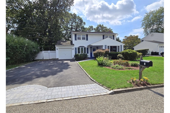 Colonial home featuring driveway and an attached garage