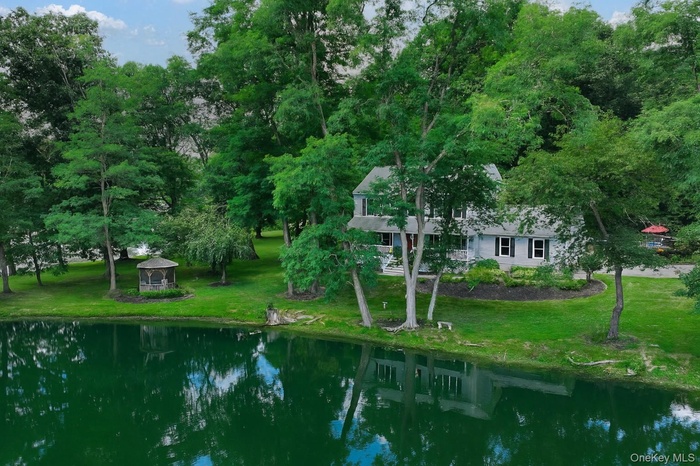 Aerial View of the front of the house with virtually altered water