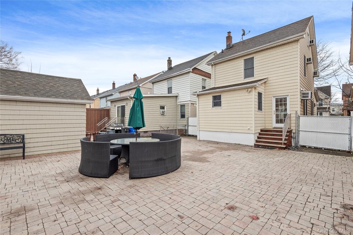 Back of house with a patio, a chimney, and outdoor dining space
