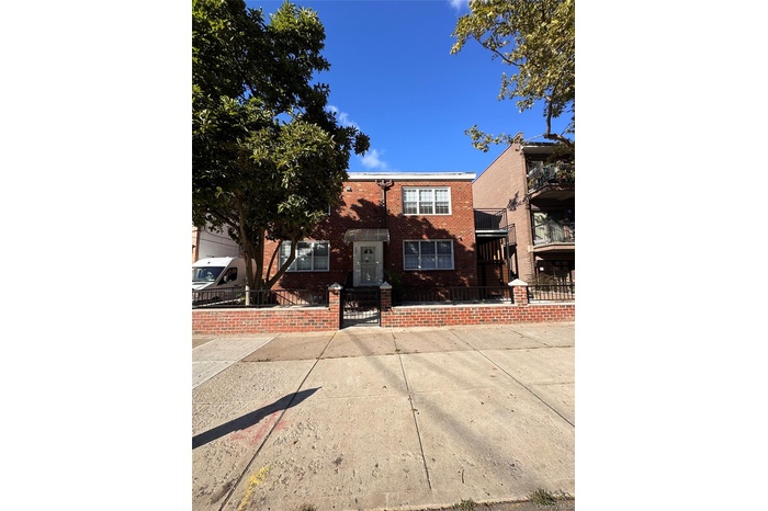 View of front of home with brick siding, a gate, and a fenced front yard
