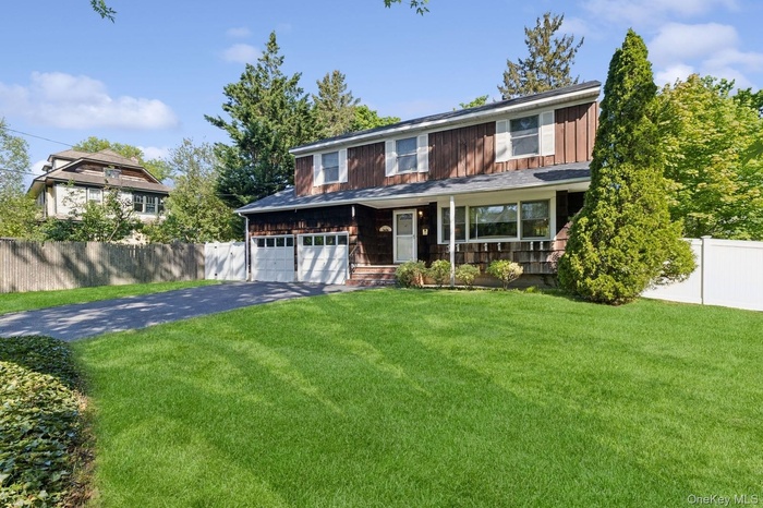 View of front of house featuring asphalt driveway, covered porch, and board and batten siding