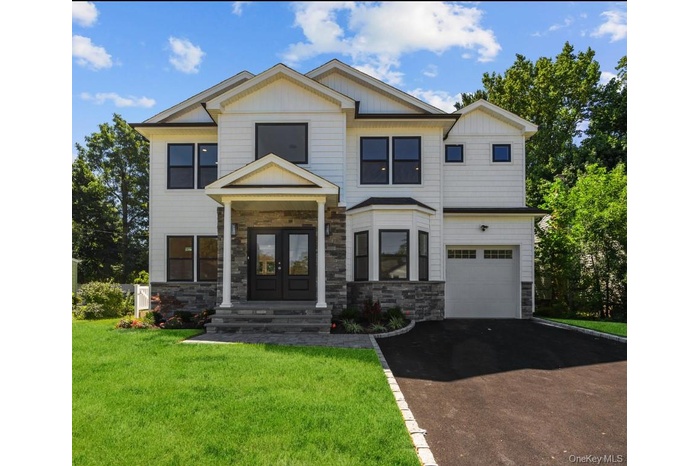 Craftsman house featuring french doors, stone siding, driveway, a front lawn, and a garage