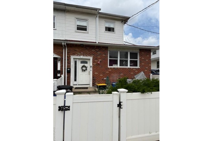 Traditional-style home with a gate and brick siding