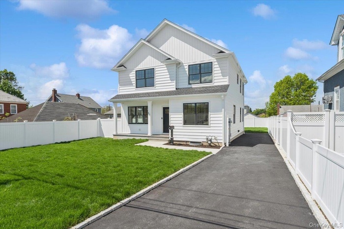 Modern inspired farmhouse featuring asphalt driveway and board and batten siding