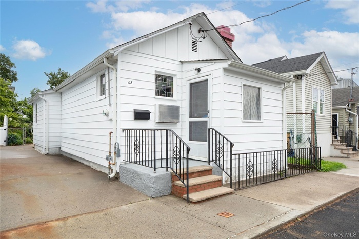 View of front of house featuring board and batten siding, entry steps, and a chimney