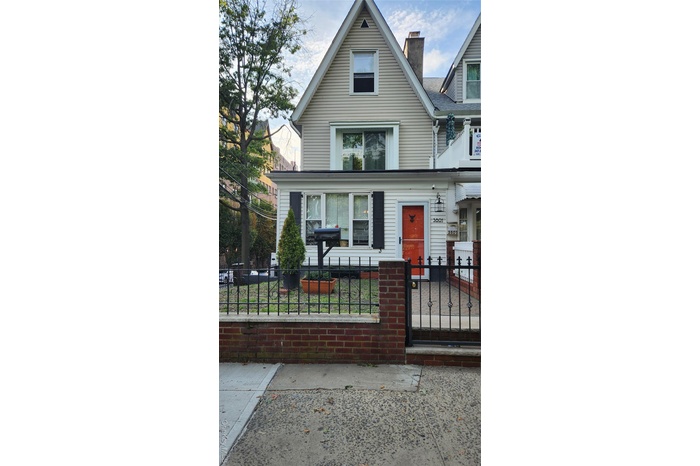 View of front of home featuring a fenced front yard, a chimney, and a gate