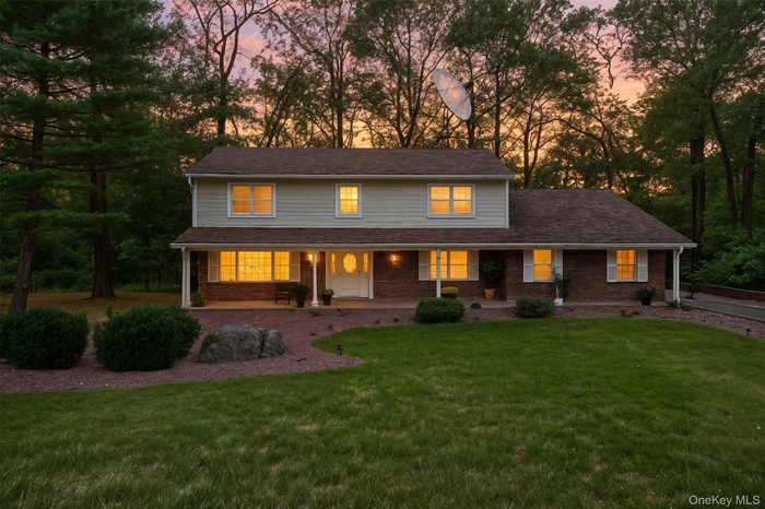Traditional home featuring covered porch and a yard