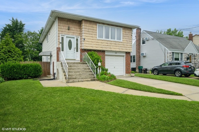 View of front of house featuring concrete driveway, brick siding, and a garage