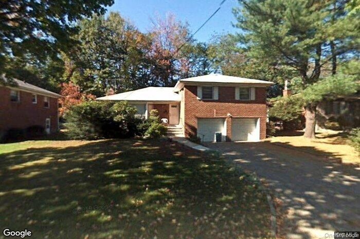 Split level home with brick siding, asphalt driveway, and an attached garage
