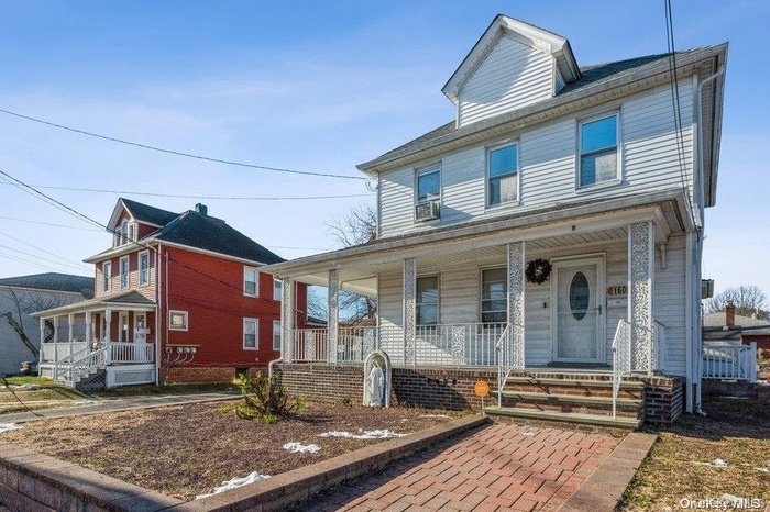 American foursquare style home featuring covered porch