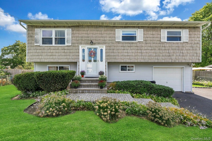Hi Ranch home featuring one car garage and asphalt driveway