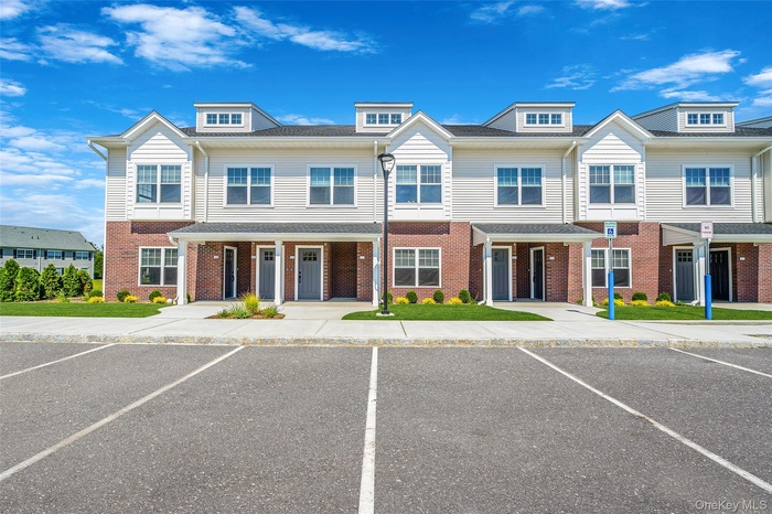 Traditional-style home with uncovered parking and brick siding