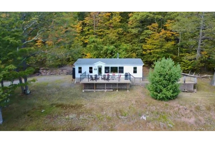 View of front of home featuring a deck and a wooded view