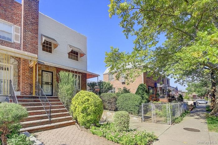 View of front of house with brick siding and a gate