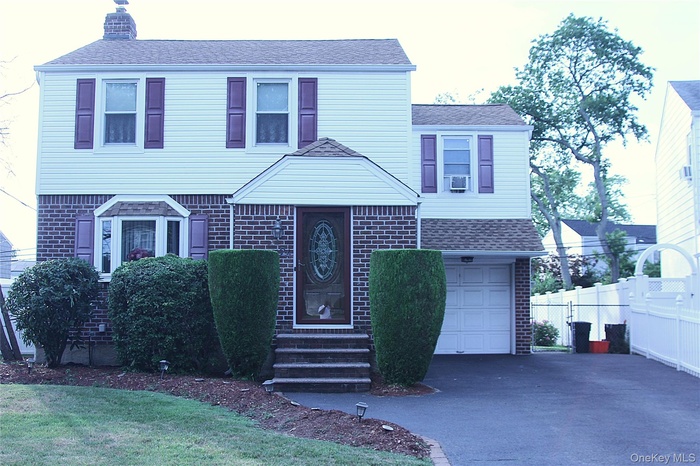 Traditional-style house featuring brick siding and a shingled roof