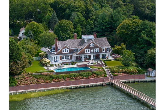 View from above of property with a nearby body of water and a pool area