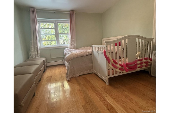Bedroom featuring light wood-type flooring and baseboard heating