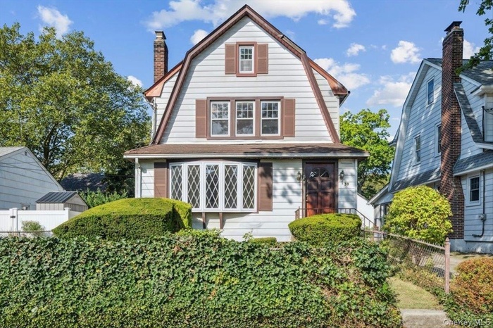 View of front of home with a gambrel roof and a chimney