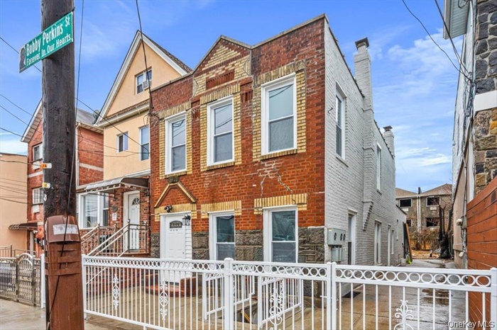View of front facade with a fenced front yard and a gate
