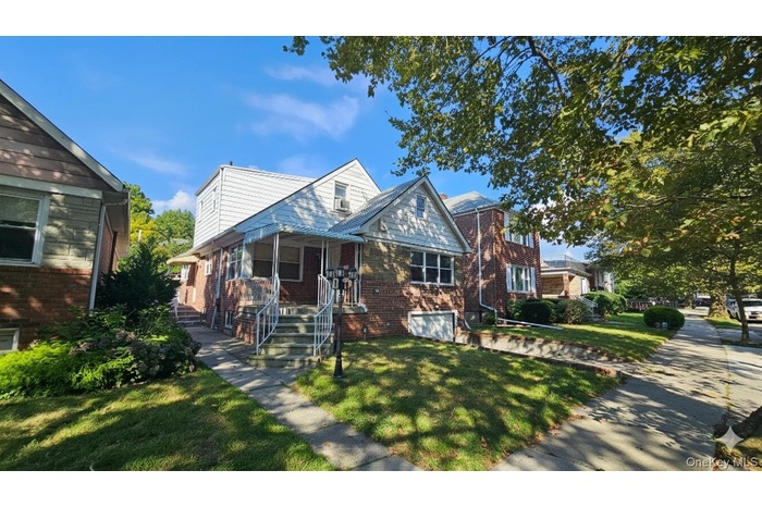 Bungalow-style house featuring brick siding and a front yard