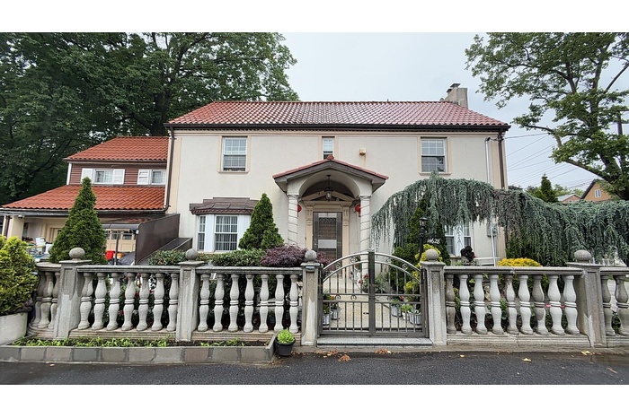 Mediterranean / spanish home with a tiled roof, a fenced front yard, a chimney, stucco siding, and a gate