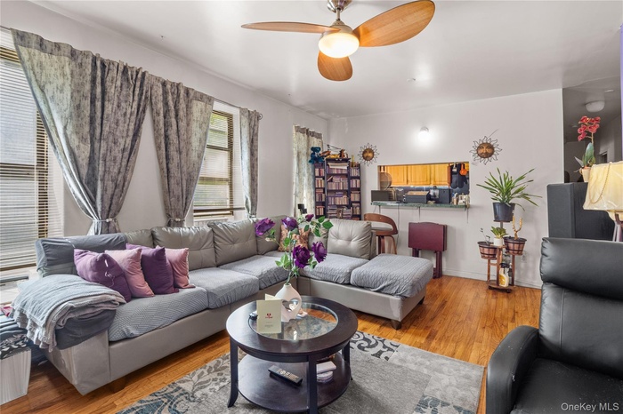 Living room with light wood-style floors and a ceiling fan