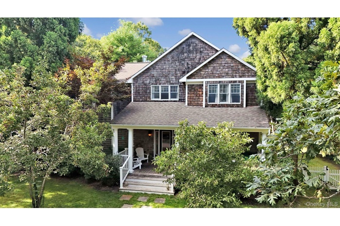 View of front of house with roof with shingles and a front lawn