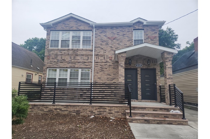 View of front of property with brick siding and a fenced front yard