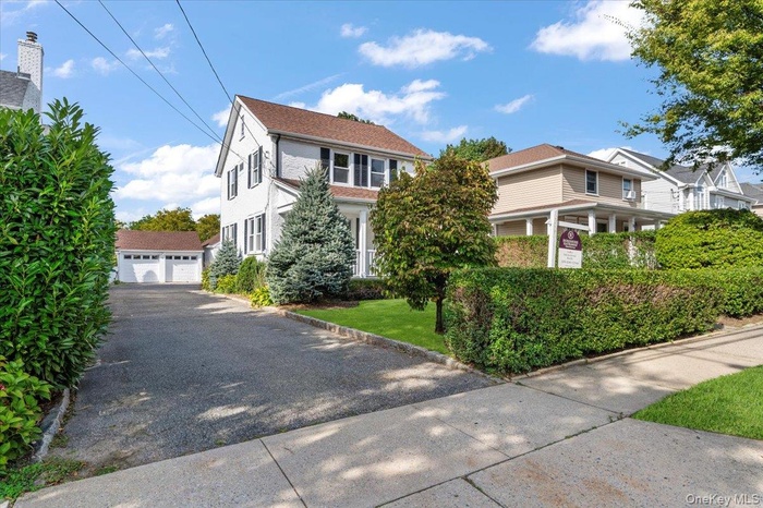 View of front of home with an outbuilding and a garage