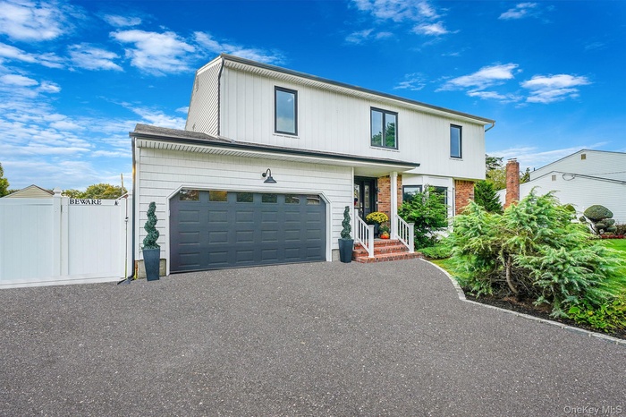 View of front of house with driveway and a garage