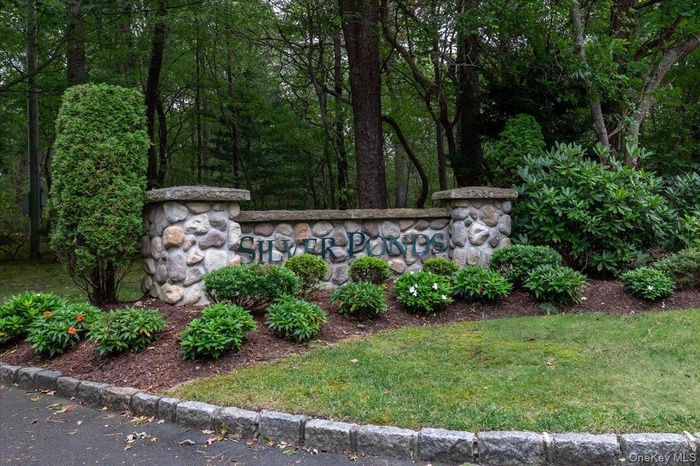 Community / neighborhood sign featuring a lawn