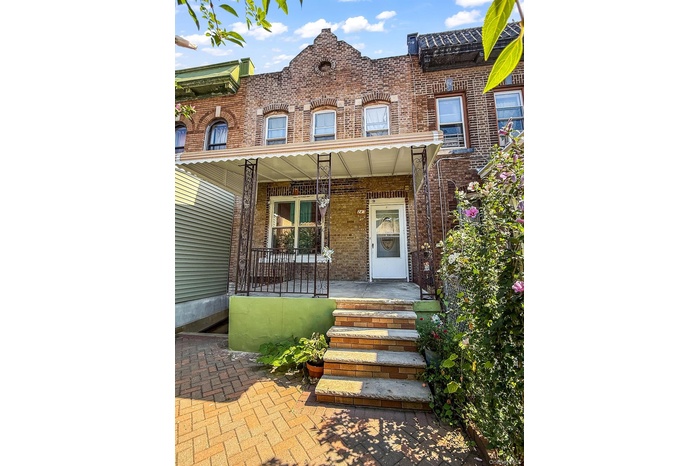 View of front of home with brick siding and a porch