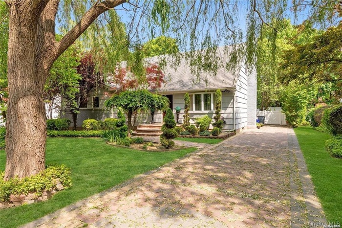 View of front of home with driveway, a front yard, and roof with shingles