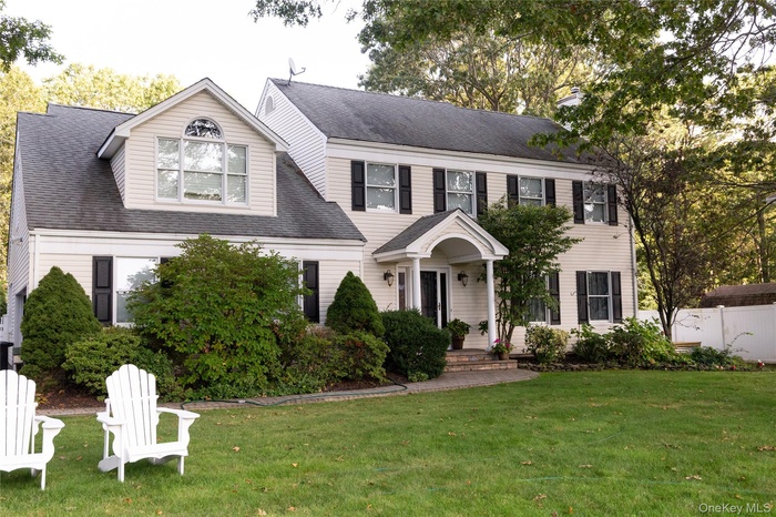 View of front of property with a shingled roof and a chimney