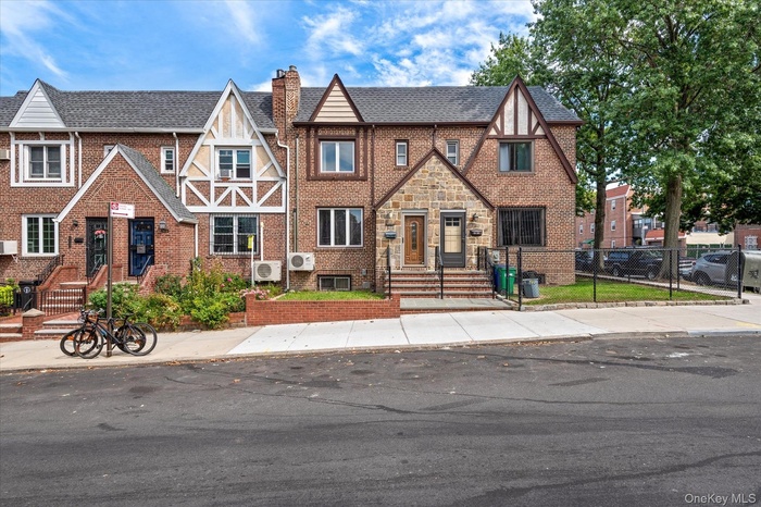 Tudor house featuring a chimney and brick siding