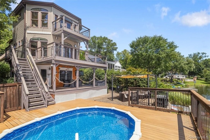 Rear view of house with a balcony and a deck
