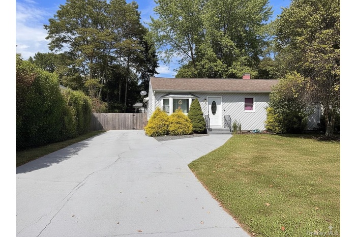 View of front of home with a chimney and concrete driveway