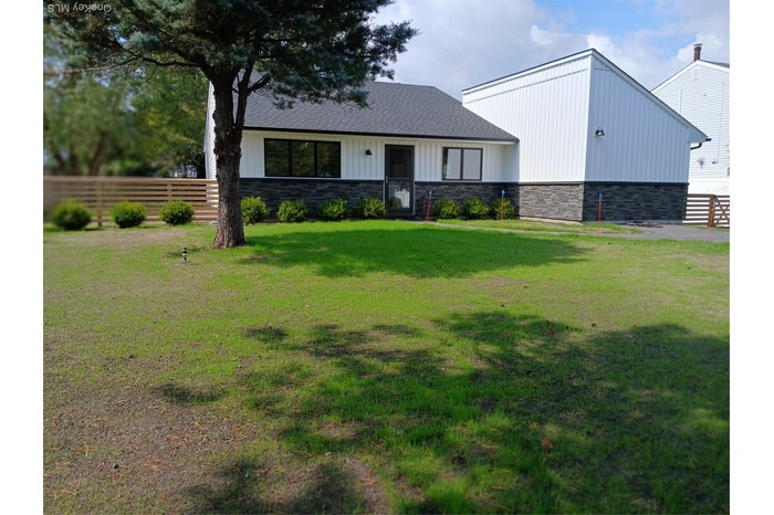 View of front of home featuring stone siding, board and batten siding, and roof with shingles