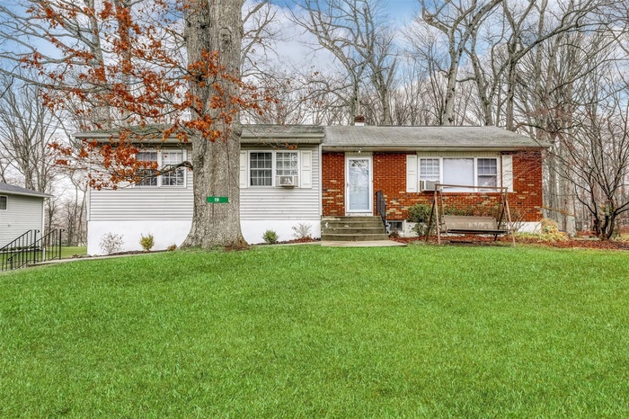 Ranch-style house featuring brick siding, entry steps, and a front lawn