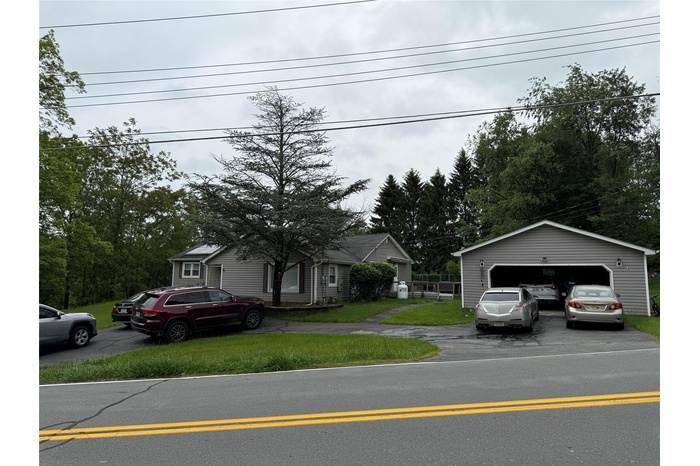 View of front of property featuring an outdoor structure and a garage