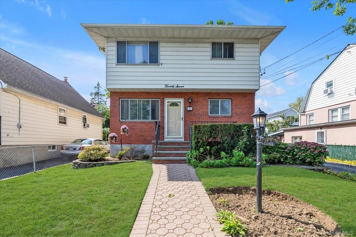 Colonial-style house featuring brick siding and cooling unit