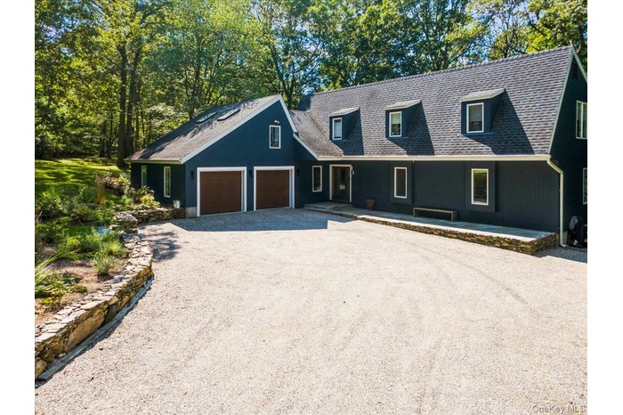 View of front of property with driveway and an attached garage